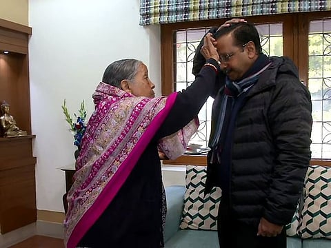 Chief Minister of Delhi Arvind Kejriwal, who is from AAP, takes the blessing of his mother before casting his vote, at his residence, in New Delhi on Saturday.