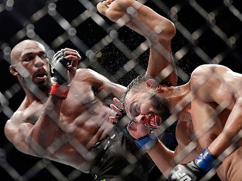 Jon Jones (left) delivers a kick to Dominick Reye during a bout at UFC 247 in Houston.