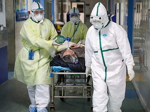 Medical workers in protective suits move a patient at an isolated ward of a hospital in Caidian district following an outbreak of the novel coronavirus in Wuhan, Hubei province, China.