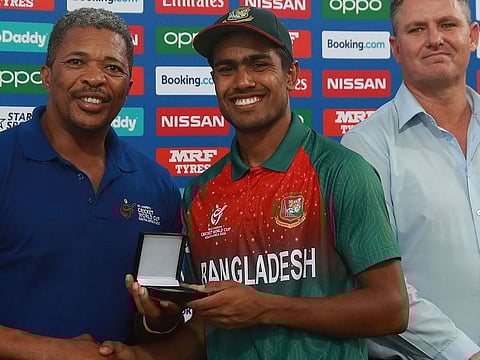 Akbar Ali is presented with the Player of the Match award from former South African cricketer Makhaya Ntini after the Cricket World Cup final
