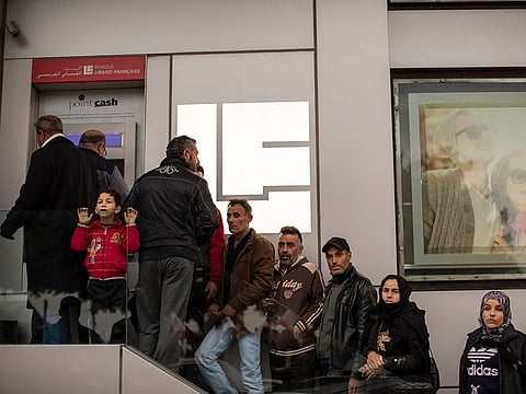 A line at an ATM machine in Tyre, Lebanon. A dizzying currency collapse, coupled with banks imposing strict withdrawal limits and prohibiting transfers abroad, has left ordinary depositors watching on helplessly.