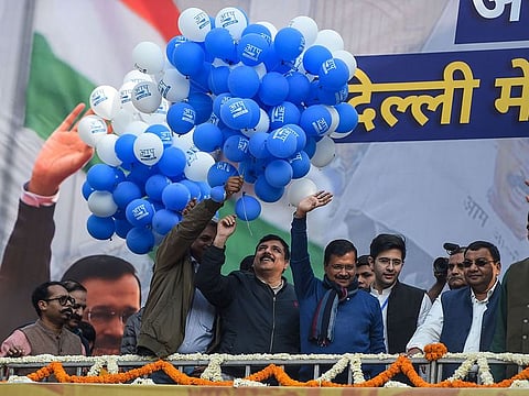 Aam Aadmi Party (AAP) chief Arvind Kejriwal (C) gestures towards his supporters at the party headquarters in New Delhi.