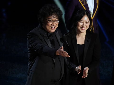 The director Bong Joon Ho, left, with Sharon Choi onstage at the Academy Awards in Los Angeles on Sunday night, Feb. 9, 2020.