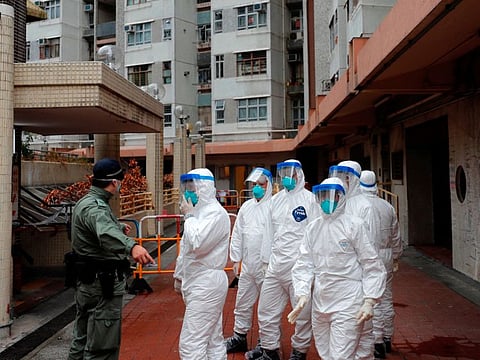 Police in protective gear wait to evacuate residents from a public housing building, following the outbreak of the novel coronavirus, in Hong Kong, on February 11, 2020.