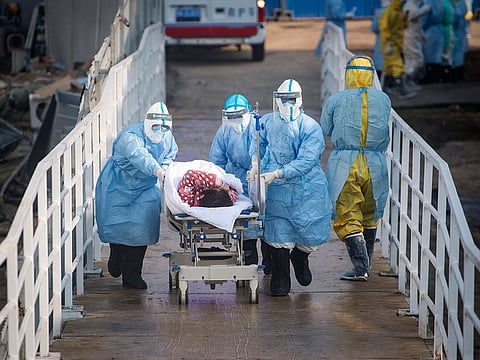 Medical workers in protective suits help transfer a group of patients into the 1,000-bed Huoshenshan temporary field hospital in Wuhan in central China's Hubei province.