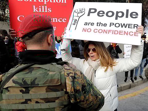 Lebanon faces the tricky question of whether to pay off a $1.2 billion bond that is due next month. Tensions on the streets are just as intense. A protester holds a placard denouncing the government during a protest against a parliament session to vote of confidence for the new government.