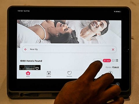 A man uses an app on a tablet to book a couple-friendly hotel room in Mumbai.