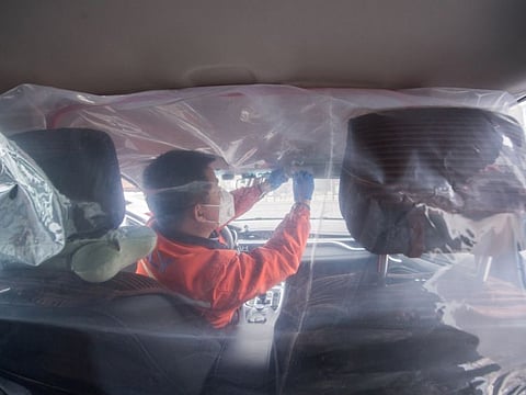 A worker installs plastic film to separate the front seats from the back, inside a vehicle for a car-hailing service as the country is hit by an outbreak of the novel coronavirus, in Taiyuan, Shanxi province, China February 14, 2020. cnsphoto via REUTERS ATTENTION EDITORS - THIS IMAGE WAS PROVIDED BY A THIRD PARTY. CHINA OUT.
