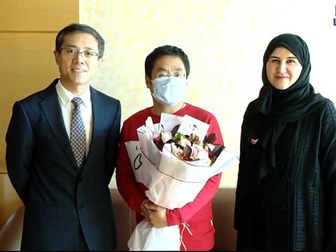 A recovered coronavirus patient in the UAE, with Consul-General of China to the UAE, Li Xuhang and Dr Fatima Al Attar, Head of International Health Regulations at the Ministry.