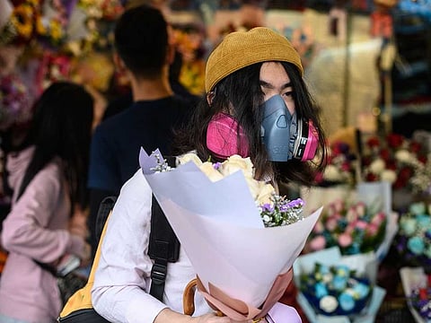 A man wearing a protective face mask as a preventative measure against the COVID-19 coronavirus, buys flowers to mark Valentine's Day in Hong Kong on February 14, 2020.