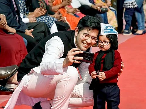 New Delhi, Feb 16 (ANI): AAP MLA Raghav Chadha clicks selfie with child who dressed as Delhi Chief minister Arvind Kejriwal during swearing-in ceremony, at Ramlila Maidan in New Delhi on Sunday. (ANI Photo)