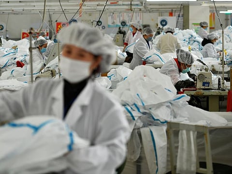 Employees work on a production line manufacturing protective suits at a clothing factory, as the country is hit by an outbreak of the novel coronavirus, in Shijiazhuang, Hebei province, China.