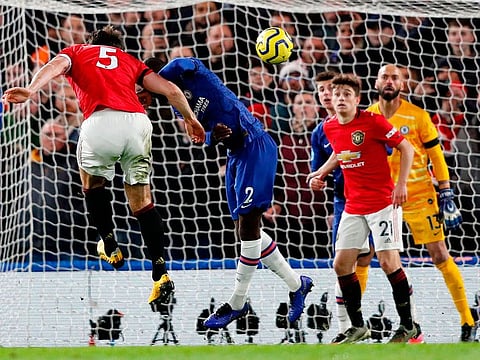 Manchester United's Harry Maguire (L) heads home their second goal during the English Premier League football match against Chelsea at Stamford Bridge in London on February 17, 2020.