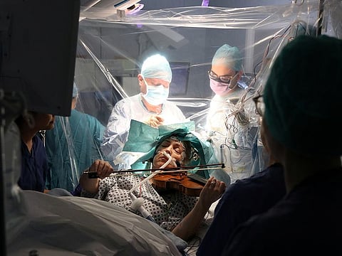 A patient Dagmar Turner, 53, plays violin while surgeons remove her brain tumour at King's College Hospital in London