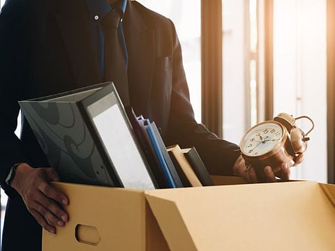 Businessman fired, leaving his office with his personal effects