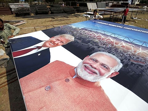 Workers preparing banners and hoardings to welcome US President Donald Trump in Ahmedabad on Wednesday.