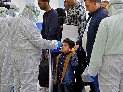 The body temperature of an Iraqi child returning from Iran is measured upon her arrival at the Najaf International Airport on February 21, 2020, after Iran announced cases of coronavirus infections in the Islamic republic.