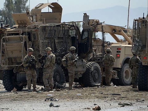 In this file photo taken on April 10, 2015 US soldiers inspect the scene of a suicide bomb attack near the airport in the Afghan city of Jalalabad.