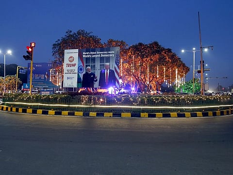 A hoarding with the images of India's Prime Minister Narendra Modi and US President Donald Trump installed next to decorated trees alongside a road ahead of Trump's visit, in Ahmedabad, on Thursday.