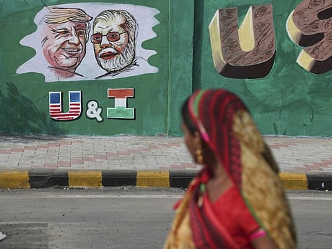 An Indian woman looks at a wall painted with portraits of U.S. President Donald Trump and Indian Prime Minister Narendra Modi ahead of Trump's visit, in Ahmedabad.