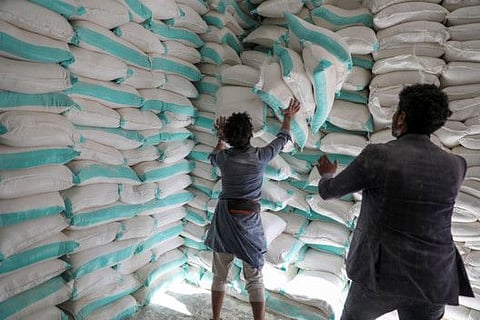 Workers handle sacks of wheat flour at a World Food Programme food aid distribution center in Sana'a. UN has largely kept quiet in public about the pressure, but behind the scenes the agency and international donors are digging in against Al Houthi demands.