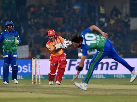 Multan Sultans' Shahid Afridi (R) attempts to catch the ball after a shot by Islamabad United's Luke Ronchi (C) during the Pakistan Super League (PSL) T20 cricket match between them at the Gaddafi Cricket Stadium in Lahore on February 22, 2020.