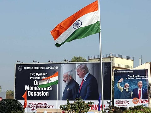 The Indian flag flies in front of billboards featuring images of Indian Prime Minister Narendra Modi and US President Donald Trump in Ahmedabad, India, on February 23, 2020.