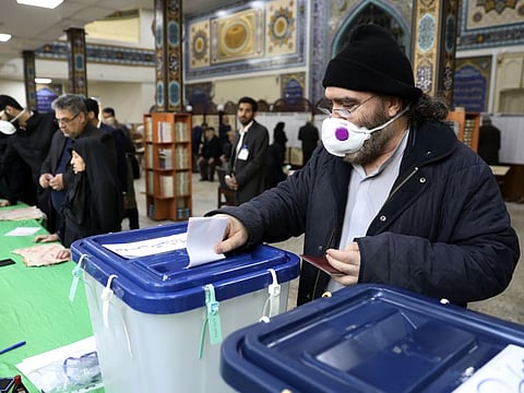 A voter casts his ballot in the parliamentary elections in a polling station in Tehran Friday.
