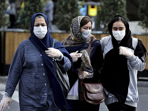 People wear masks to help guard against the Coronavirus on a street in downtown Tehran, Iran. Iran's semi-official ILNA news agency has reported on Monday that the death toll from the Covid-19 infection in the city of Qom has reached 50.