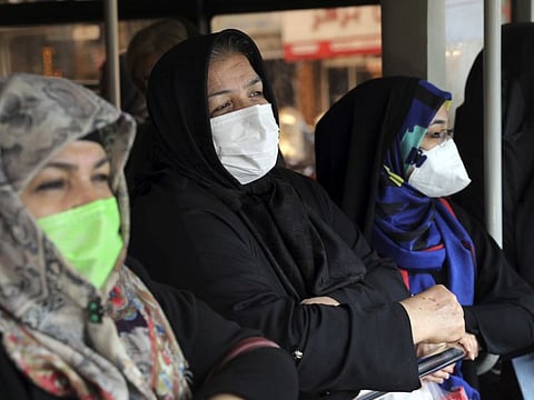Commuters wear masks to help guard against the Coronavirus on a public bus in downtown Tehran.