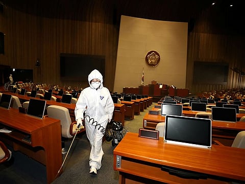 Employees from a disinfection service company sanitize the National Assembly in Seoul, South Korea, February 25, 2020.