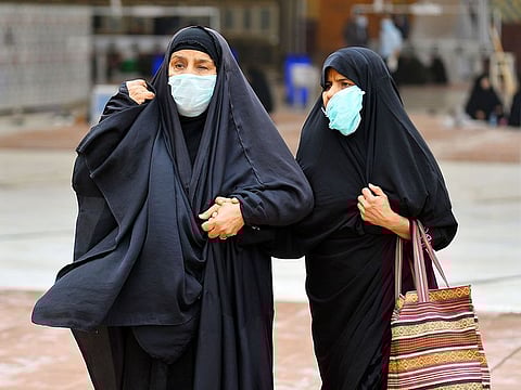 Women wearing masks walk through the courtyard of the shrine of Imam Ali in the Iraqi city of Najaf, where the first case of coronavirus COVID-19 has been documented in Iraq.