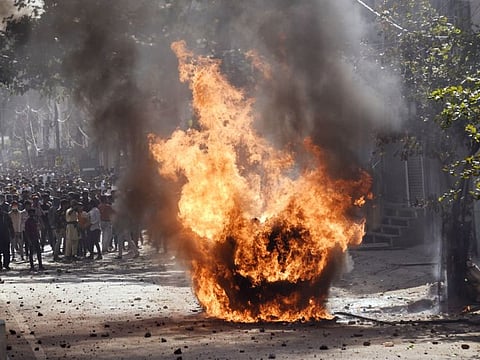 Vehicles set ablaze as protestors throw brick-bats during clashes between two groups over the Citizenship act, at Jafrabad in North-East Delhi on Monday.
