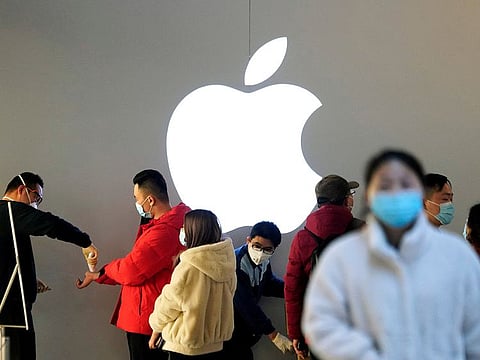 People wearing protective masks wait for checking their temperature in an Apple Store, in Shanghai, China, as the country is hit by an outbreak of the novel coronavirus, February 21, 2020.