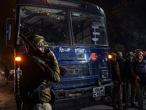 New Delhi police stand watch at a roadblock on a stretch of highway between a Hindu area of the Maujpur neighborhood and a nearby Muslim-dominated area called Jafrabad on Tuesday night, Feb. 25, 2020.