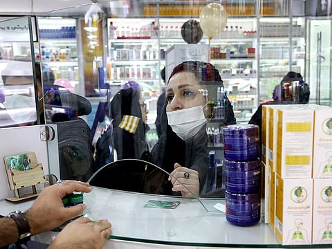 A customer talks with a Pharmacist at a drugstore in downtown Tehran on February 25.