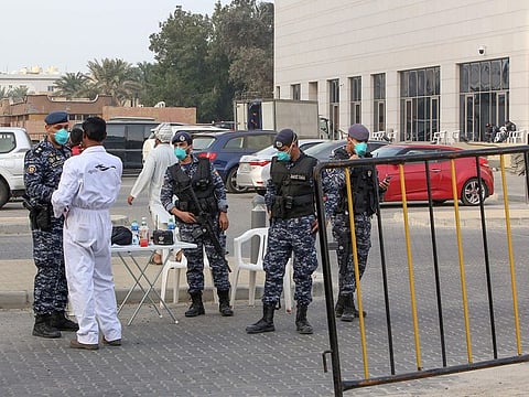 Members of Kuwait's national guard wearing safety masks keep watch outside a hotel in the capital where Kuwaitis returning from Iran are quarantined and tested for coronavirus COVID-19, on February 24.