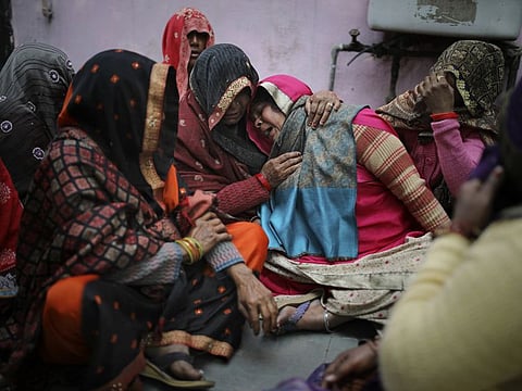 Family members of Rahul Solanki, who was killed during the clashes, weeping outside a mortuary in New Delhi yesterday.