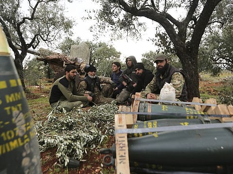 Syrian fighters take a break near the village of Neirab, in Idlib province, Syria.
