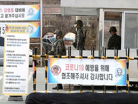 South Korean army soldiers wearing face masks stand guard at a checkpoint of a military base in Daegu, South Korea, Wednesday, Feb. 26, 2020.