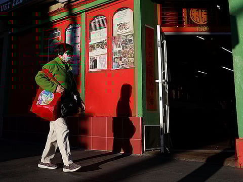 A woman wearing a face mask walks through the Chinatown section of San Francisco, California, U.S., February 26, 2020.