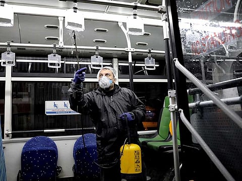 A worker disinfects a public bus against coronavirus in Tehran, Iran, in early morning of Wednesday, Feb. 26, 2020.