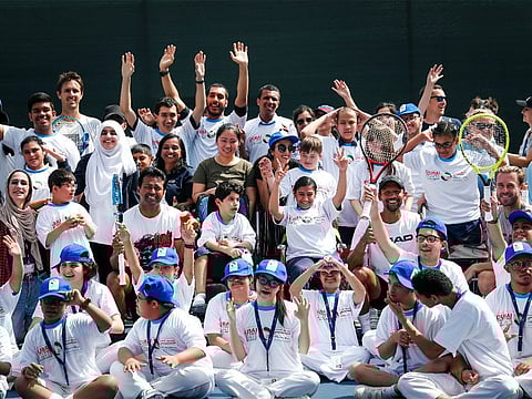 Leander Paes poses with children after a clinic during the Dubai Duty Free Tennis Championships.