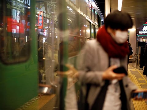 A passenger wearing a protective face mask, following an outbreak of the coronavirus, gets off from a tram in Sapporo, Hokkaido, Japan, on February 25.