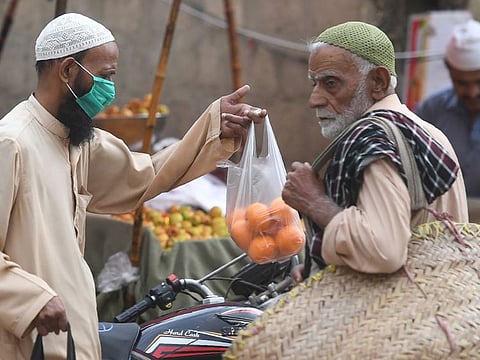 A resident wears a face mask at a market in Karachi on Friday. The court on February 21 had ordered all departmental stores in the province to stop using harmful plastic bags and water bottles.