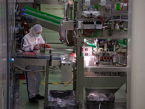 A worker checks yogurt coming off the production line at the Mengniu dairy factory in Beijing.