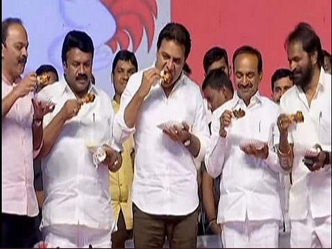 Ministers eat chicken on stage