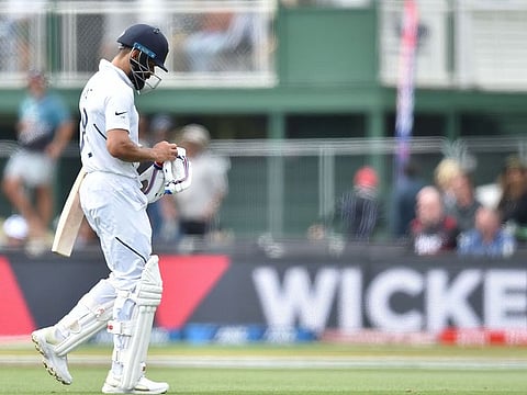 India's captain Virat Kohli (R) walks after being bowled LBW on day one of the second Test cricket match between New Zealand and India at the Hagley Oval in Christchurch on February 29, 2020