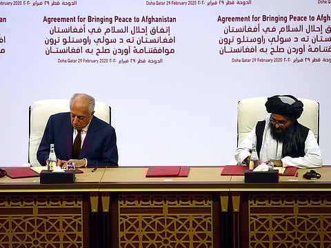 Mullah Abdul Gani Baradar, the leader of the Taliban delegation, signs an agreement with Zalmay Khalilzad, US envoy for peace in Afghanistan, at a signing agreement ceremony between members of Afghanistan's Taliban and the US in Doha, Qatar on Saturday.