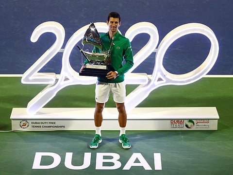Novak Djokovic poses with the men's singles winner's trophy, his fifth one in Dubai.